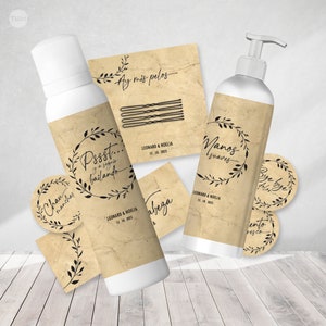 Puede incluir: Un conjunto de detalles de boda con un diseño rústico en marrón y negro. Los detalles incluyen una botella de loción para manos, una botella de acondicionador para el cabello y varias pegatinas redondas pequeñas. Las etiquetas de las botellas y las pegatinas presentan un diseño de corona floral con el texto "Pssst... y a seguir bailando", "Nanos suaves" y "Bye bye dolor".