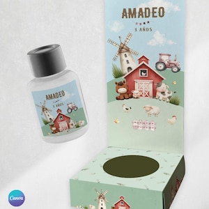 Op de afbeelding: Een doorzichtige fles met een zwarte dop en een bijpassende displaydoos. Beide hebben een boerderijthema-illustratie met een rode schuur, windmolen, tractor en diverse boerderijdieren. De tekst "AMADEO 3 AÑOS" is zichtbaar.