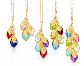 May include: Five gold-tone necklaces featuring clusters of marquise-cut colored crystals and textured gold-tone leaf charms. The pendants vary in the number of crystal and leaf elements, showcasing a range of vibrant hues including red, blue, pink, green, yellow, purple, and clear stones.