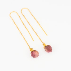 May include: A pair of gold chain earrings with pink and purple gemstone drops.