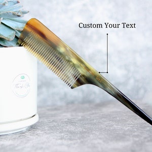 May include: A brown and black comb with a long, thin handle. The comb has a custom text inscription that reads "Custom text".