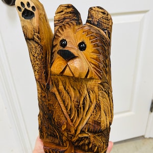 cute cedar bear chainsaw carving with one paw up waving