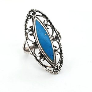 Könnte beinhalten: Ein silberner Ring mit einem blauen, ovalen Stein, der in einem filigranen Design gefasst ist.