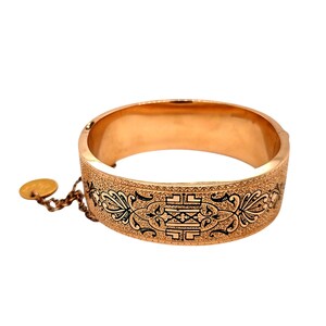 Brazalete plano con bisagras de oro amarillo de 14 k y esmaltado negro. 20 mm de ancho.