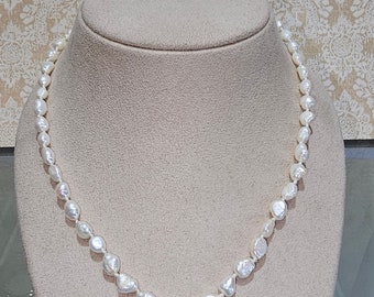 Circa 1980, a 20" knotted strand of baroque cultured pearls with 14k yellow gold clasp.