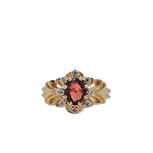Anello in oro giallo 14k con granato ovale e diamanti. Misura 9,25