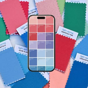 Może przedstawiać: Smartfon wyświetlający paletę kolorów z różnymi odcieniami niebieskiego, czerwonego, fioletowego i koralowego. Telefon jest otoczony próbnikami tkanin w różnych odcieniach niebieskiego, różowego i czerwonego. Próbniki mają etykiety tekstowe wskazujące nazwy kolorów i kluczowe kolory.