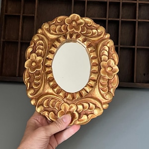 Ornate oval wall mirror in hand-carved wooden gold frame with floral pattern - Decorative folk art mirror 9.5“x8“ Vintage