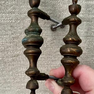 May include: Antique bronze cabinet pulls with a decorative, ornate design. The pulls have a dark patina and a classic, vintage aesthetic. The hardware features a detailed, symmetrical shape, perfect for adding a touch of elegance to furniture or cabinetry.