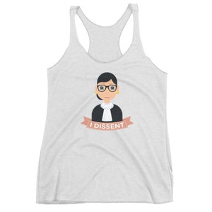 May include: A white tank top with a cartoon illustration of a woman wearing glasses and a judicial robe. The text "I DISSENT" is on a pink ribbon below the illustration.