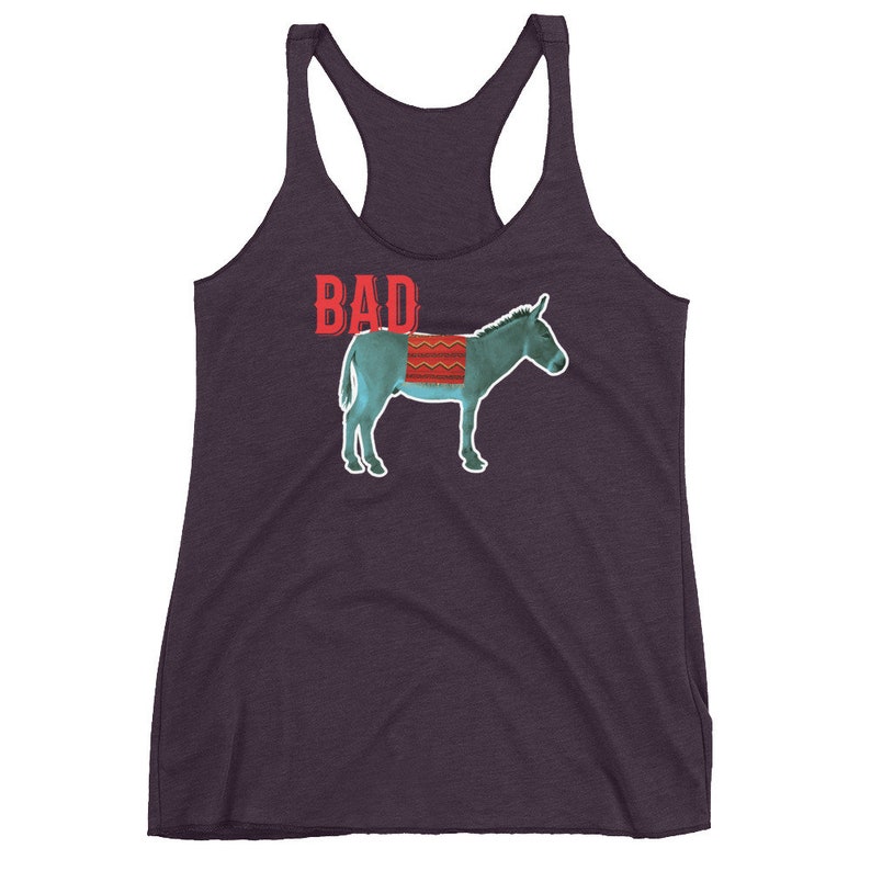 May include: A purple tank top with a blue donkey wearing a red and white blanket. The text "BAD" is printed in red above the donkey.