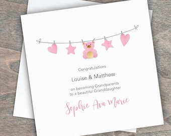 Puede incluir: Una tarjeta rosa y blanca con una hilera de corazones, estrellas y un osito de peluche colgando. La tarjeta dice "Felicidades Louise & Matthew por convertirse en abuelos de una hermosa nieta Sophie Ava Marie".