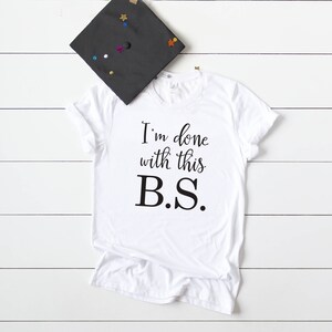 May include: White t-shirt with black text that reads "I'm done with this B.S."