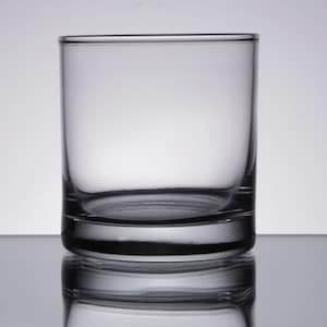 May include: A clear glass tumbler with a thick base. The glass is empty and has a slight reflection of the background.