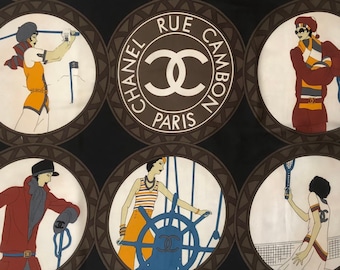 May include: A black square silk scarf featuring eight circular illustrations of figures in various activities, surrounding a central circle with the text CHANEL RUE CAMBON PARIS and the interlocking CC logo. The bottom right corner reads CHANEL PARIS.