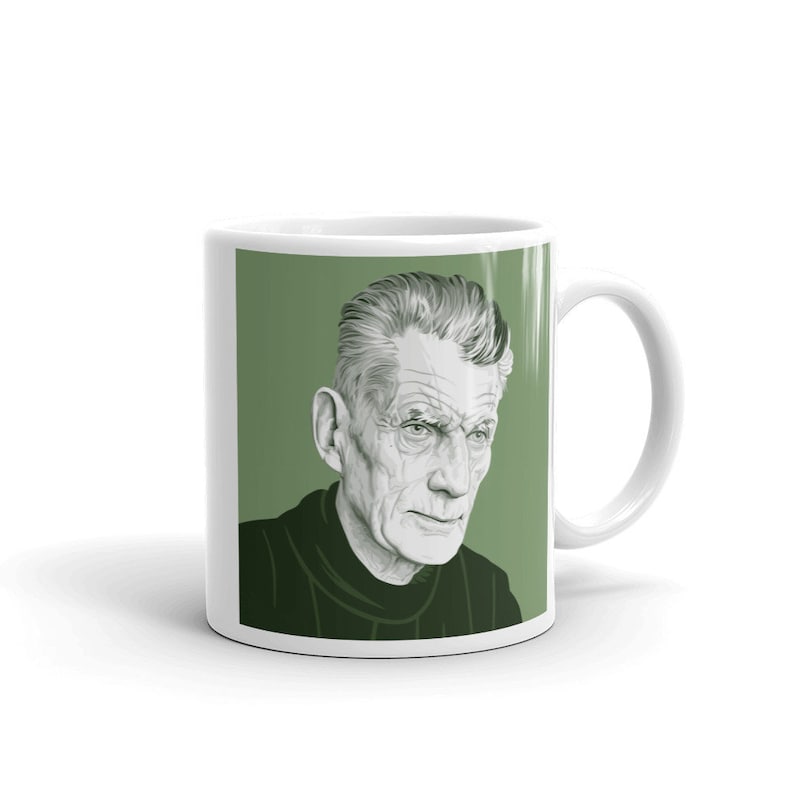 May include: White ceramic mug with a green background featuring a black and white illustration of a man with grey hair. The man is looking to the right.