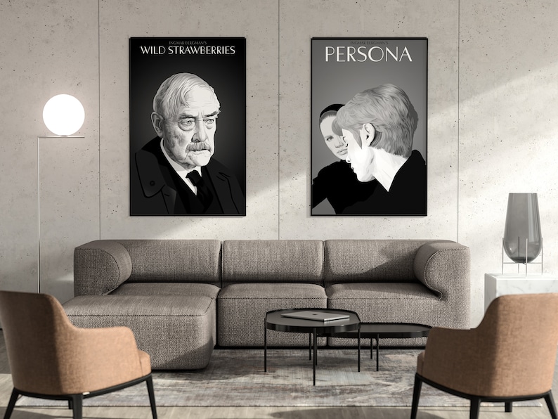 Op de afbeelding: Twee zwart-witte filmposters hangen aan een witte muur boven een grijze bank. De poster aan de linkerkant zegt "WILD STRAWBERRIES" en toont een mannengezicht. De poster aan de rechterkant zegt "PERSONA" en toont de gezichten van twee vrouwen.