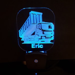 May include: Blue LED night light with a white silhouette of a dump truck and the name "Eric" underneath.
