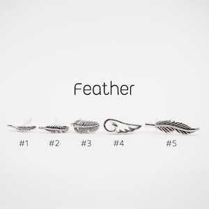 May include: A collection of silver-toned feather-themed earrings. The word "Feather" is displayed above the earrings. Each earring is numbered from #1 to #5, showcasing different feather designs, including a wing-shaped earring.