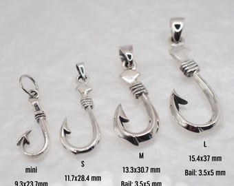 以下が含まれることがあります： 異なるサイズのシルバー製の釣り針ペンダントが5つ。ペンダントはすべてシルバー製で、シンプルなデザインです。最も小さいペンダントは「ミニ」と表示され、9.3 x 23.7 mmです。次のサイズは「S」と表示され、11.7 x 28.4 mmです。次のサイズは「M」と表示され、13.3 x 30.7 mmです。次のサイズは「L」と表示され、15.4 x 37 mmです。最大のペンダントはラベルがなく、5つのうち最大です。