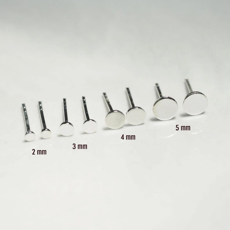 May include: A set of eight silver earring posts in various sizes, ranging from 2 mm to 5 mm in diameter. The earring posts are arranged in order of size, with the smallest on the left and the largest on the right.