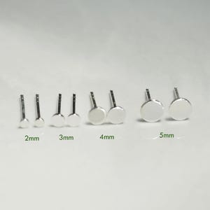 May include: A set of six pairs of silver stud earrings in various sizes, ranging from 2mm to 5mm. The earrings are displayed on a white surface.