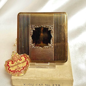Vintage Kigu compact. Square powder compact. Gold with engine turned design. Unused and boxed. 1952.