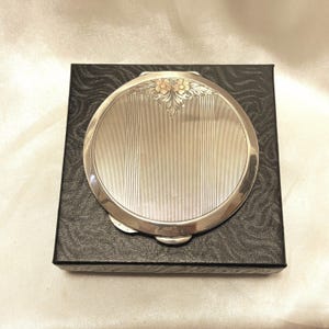 Pretty vintage English sterling silver powder compact. Engine turned with rose gold flower decor. Hallmarked with Queen&#39;s coronation 1953.