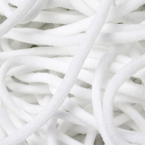 Può includere: Primo piano di un mucchio di cordoncino elastico bianco, comunemente usato per realizzare maschere per il viso o altri lavoretti.