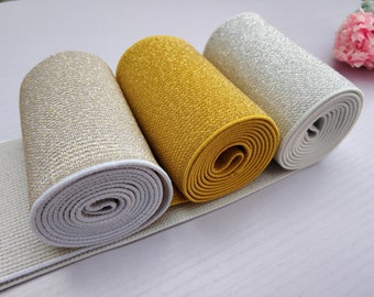 Puede incluir: Tres rollos de cinta elástica con acabado brillante. Los rollos son en dorado, plateado y blanco.