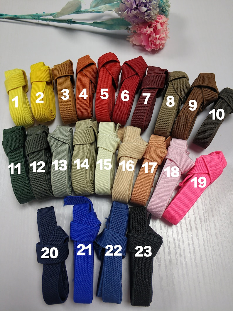 May include: Twenty-three different colors of elastic webbing, each with a number from 1 to 23. The webbing is folded in half and tied in a knot.