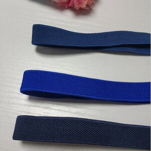 May include: Three different colors of elastic band, navy blue, royal blue, and black. The elastic bands are all the same width and have a textured surface.