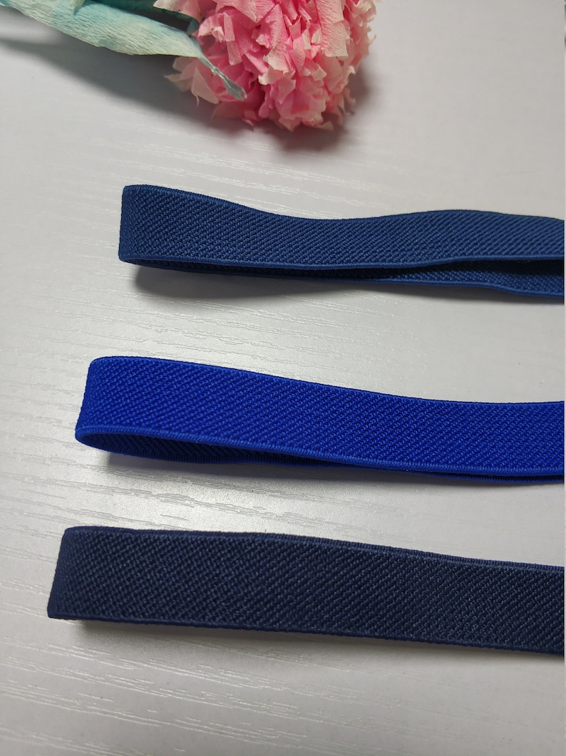May include: Three different colors of elastic band, navy blue, royal blue, and black. The elastic bands are all the same width and have a textured surface.
