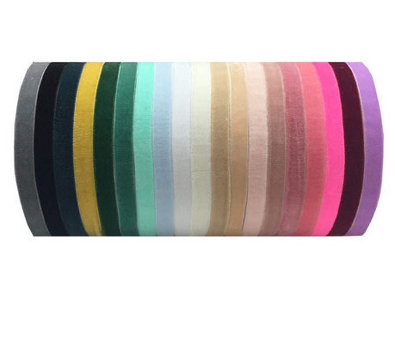 May include: A collection of 18 velvet ribbon spools in various colors, including gray, black, yellow, green, light blue, white, beige, pink, fuchsia, and purple.