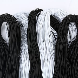 May include: A close-up of black and white elastic cord. The cord is bundled together and appears to be soft and stretchy.