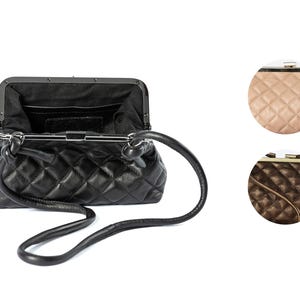 The interior view of a black quilted handbag, showing compartments and a clasp closure, against a white background. Colors of quilted bags shown.