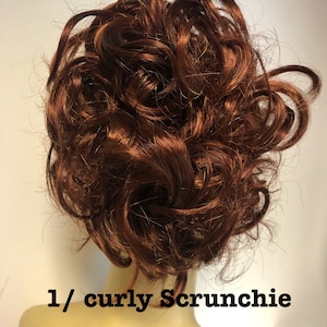 May include: A brown curly hair scrunchie. The scrunchie is on a mannequin head.