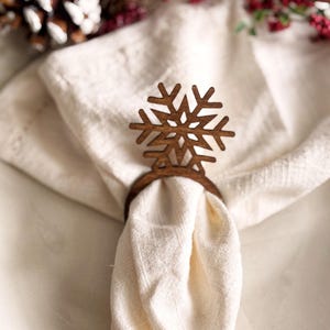 May include: A wooden snowflake napkin ring in brown, perfect for adding a festive touch to your holiday table setting.
