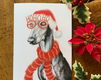 Könnte beinhalten: Weihnachtskarte mit einem Windhund, der einen Weihnachtsmannhut, einen roten Schal und eine Brille mit "HOHOHO" trägt. Festliches Stechpalmenlaub und ein Weihnachtsstern schmücken den Hintergrund.
