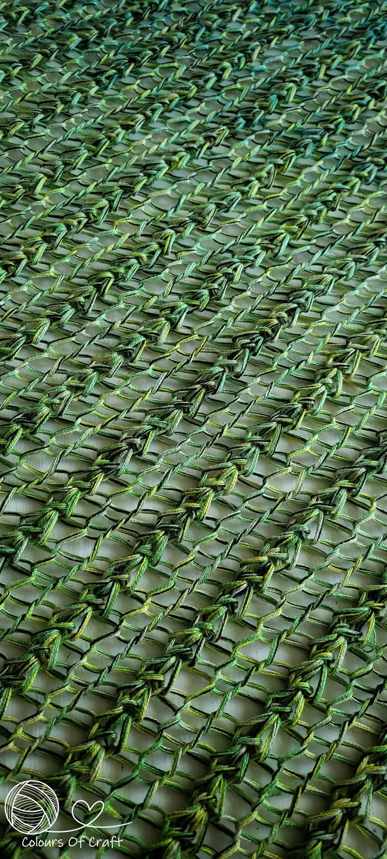 Op de afbeelding: Close-up van een groen en geel gehaakt stof met een ruitpatroon. De stof is gemaakt met verschillende tinten groen en geel garen.