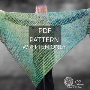 Op de afbeelding: Een vrouw draagt een groen en blauwe gehaakte sjaal met de tekst "PDF PATTERN WRITTEN ONLY" op een wit rechthoek. De tekst "Colours Of Craft" staat onder een bol garen met een hart.