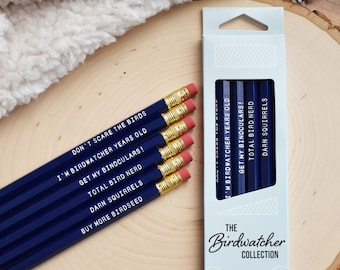 May include: A set of six blue pencils with humorous birdwatching-themed sayings printed on them. The pencils are packaged in a white box with the text "The Birdwatcher Collection" and "Set of 6 No. 2 Pencils".