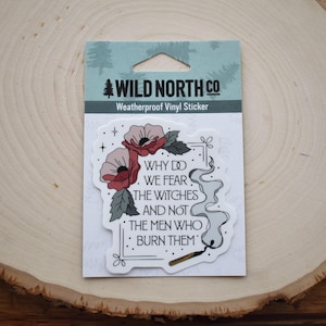 Pu&ograve; includere: Un adesivo bianco con un design di papavero rosso e il testo "WHY DO WE FEAR THE WITCHES AND NOT THE MEN WHO BURN THEM". L'adesivo &egrave; resistente alle intemperie ed &egrave; fatto di vinile.