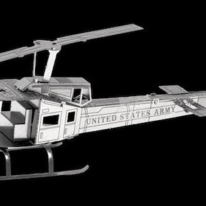 May include: A silver-colored metal model of a helicopter against a black background. The words "UNITED STATES ARMY" are printed on the side. The model has a main rotor, tail rotor, and landing skids. The tail has the number "03607".