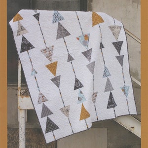 May include: A quilt pattern featuring a white background with rows of grey, blue, and gold triangles. The quilt is draped over a white metal railing. The text "Sergeant Pepper" is printed below the quilt. The text "AbbeyLaneQuilts.com" and "#205" are printed below the text "Sergeant Pepper".