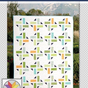 May include: A quilt pattern called "Division" by "a bright corner...quilts & patterns..." featuring a white background with a geometric pattern of green, orange, blue, and black fabric squares and triangles.
