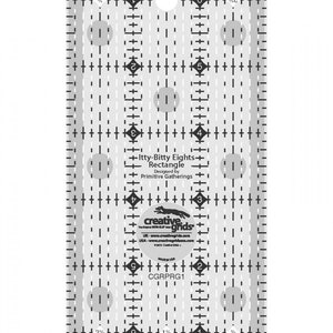May include: A clear plastic quilting ruler with a grid pattern and circles. The ruler is labeled "Itty-Bitty Eights Rectangle" and "Creative Grids".