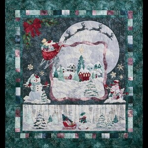 May include: A square Christmas quilt featuring a central winter village scene under a large moon, with Santa in a red sleigh pulled by reindeer above. The border is dark green with a patchwork frame, including snowmen, pine trees, and red bows.