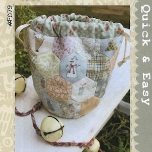 May include: A beige and brown patchwork fabric drawstring bag with a snowman design. The bag is labelled "All for Christmas Treat Bag" and "Quick & Easy".