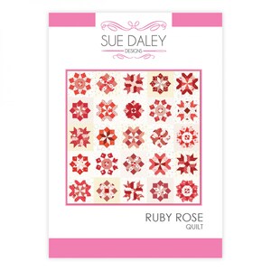 Op de afbeelding: Een quiltpatroonontwerp met een rode en witte quilt met een geometrisch patroon. Het patroon heet "Ruby Rose Quilt" en is van Sue Daley Designs.